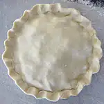 Dough in a pie crust shell ready for filling.