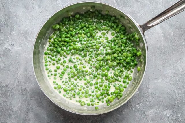 fixing creamed peas in a saucepan.