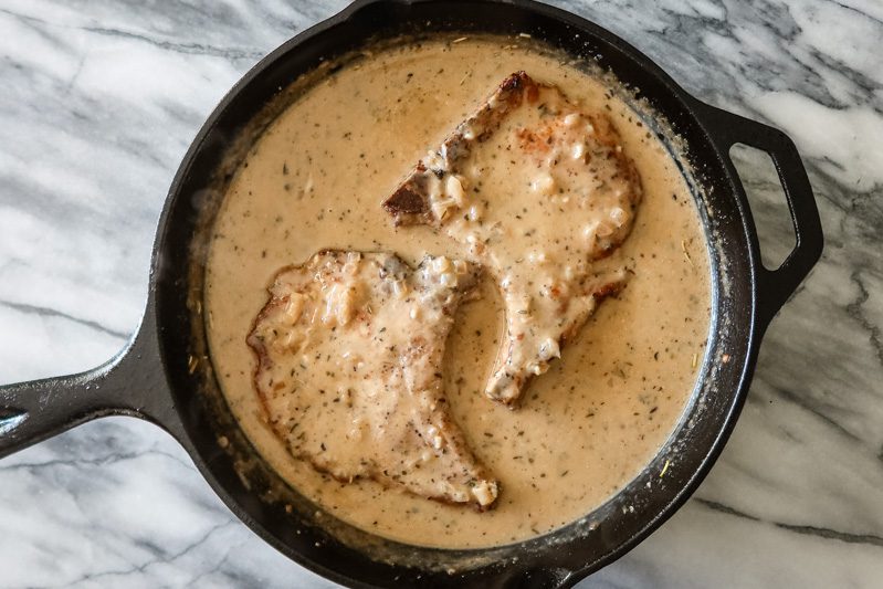 pork chops with creamy apple cider sauce in the skillet