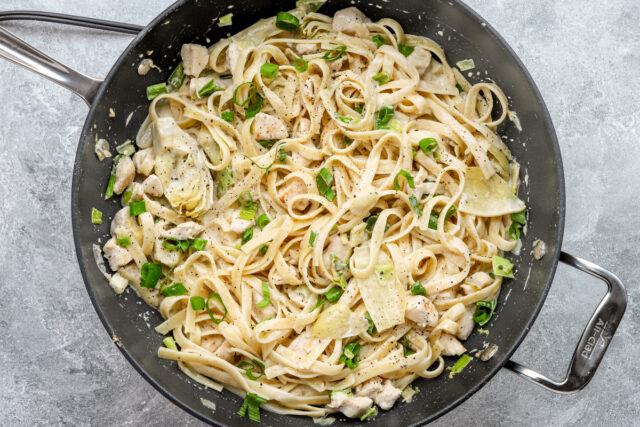 The cooked fettuccine and Parmesan cheese is added to the creamy chicken pasta.