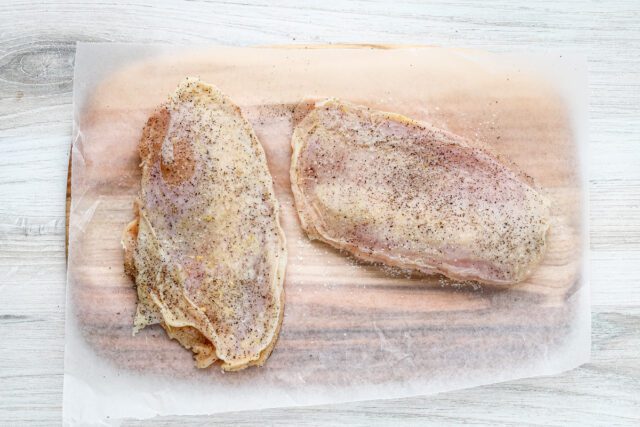 Chicken breasts are seasoned and ready to cook.