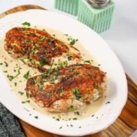 Baked chicken thighs with creamy sauce and fresh herbs.