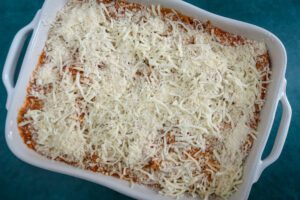 Top the spaghetti casserole with cheese in a baking dish