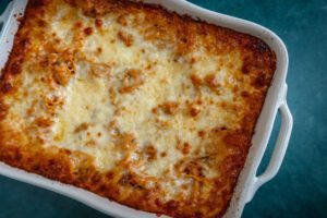 Baked spaghetti casserole in a white baking dish.