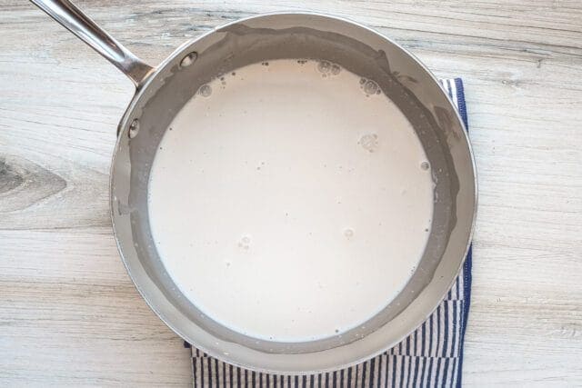 Creamy sauce cooking in a saucepan.
