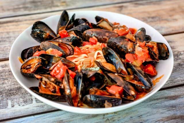 A bowl of Creole style mussels with linguine.