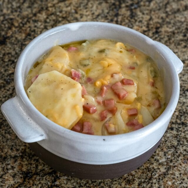 Slow cooker scalloped potatoes and diced ham in a bowl.
