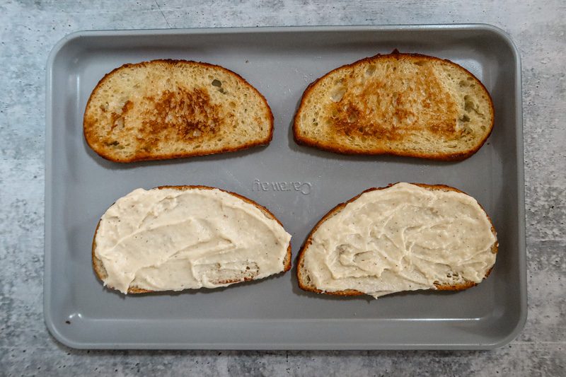 croque monsieur sandwich prep: preparing the toasted bread with bechamel sauce