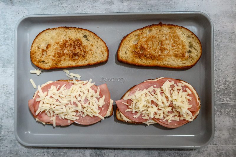 croque monsieur sandwich prep: adding the ham and cheese to the sandwich