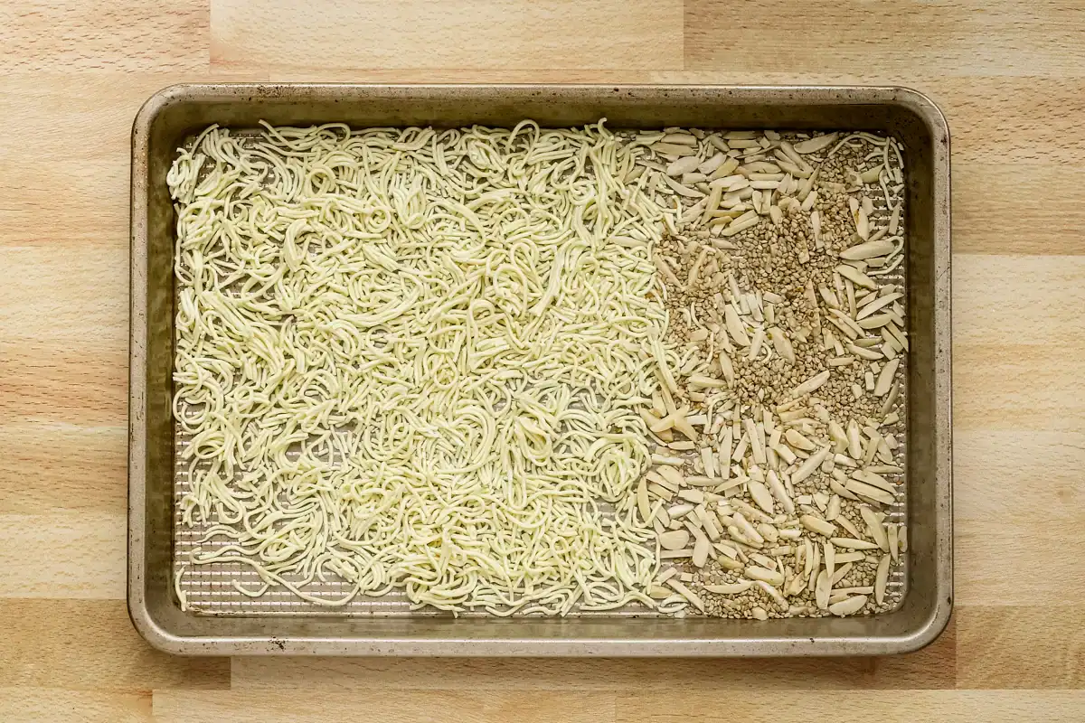 Raw instant noodles on baking sheet with seasonings.