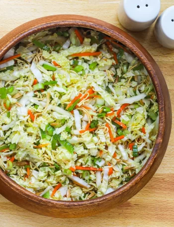 A crunchy napa cabbage and ramen noodle salad in a serving bowl.