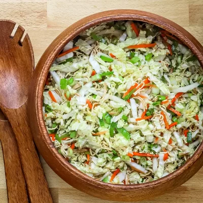 Steamed vegetable and noodle salad in a wooden bowl.