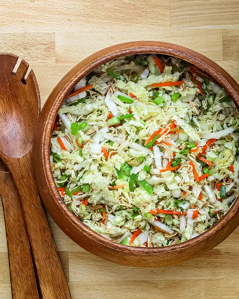 Steamed vegetable and noodle salad in a wooden bowl.