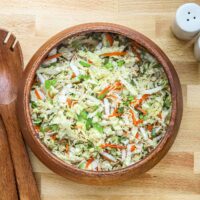 Cabbage and vegetable coleslaw in wooden bowl.