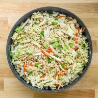 Fresh vegetable noodle salad with cabbage, carrots, and green onions.