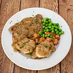 Roast beef with brown gravy, green peas, and glazed carrots on a white plate.