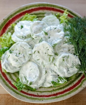cucumber salad with sour cream and dill on a plate