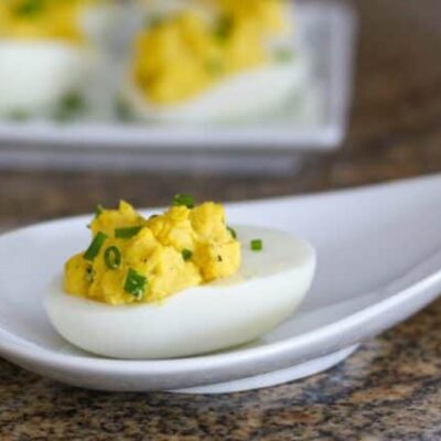 curried deviled eggs with chopped chives for garnish