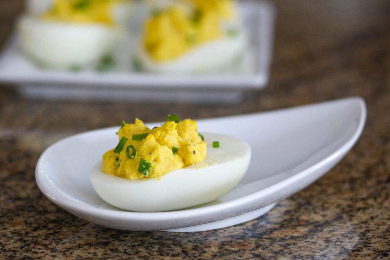 curried deviled eggs with chopped chives for garnish