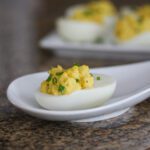 deviled eggs with curry powder, topped with sliced chives