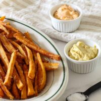 Sweet potato fries with curry mayo and Sriracha mayo in ramekins for dipping.
