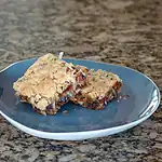Blended cookie bar with chocolate and nuts on a blue plate.