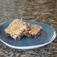 Blended cookie bar with chocolate and nuts on a blue plate.