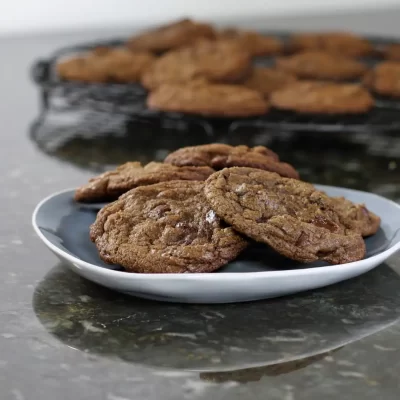 Cookies on a white plate with more cookies in the background.