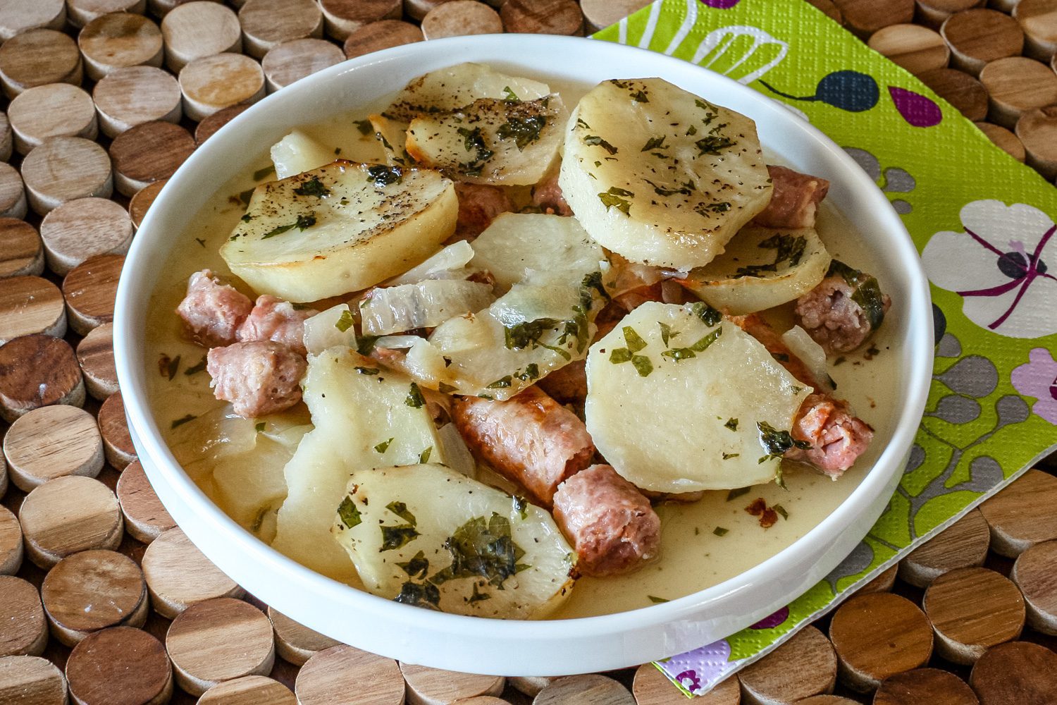 A plate of dublin coddle, potatoes and sausages