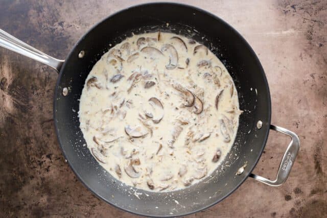 Creamy mushroom sauce simmering in a pan.