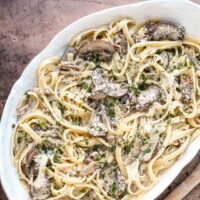 Creamy mushroom Alfredo pasta dish with Parmesan cheese and fresh herbs.