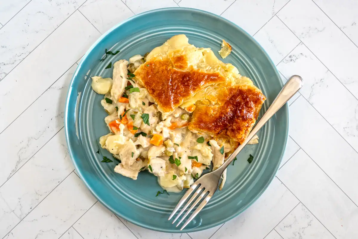 A serving of chicken pot pie that is topped with patchwork puff pastry.