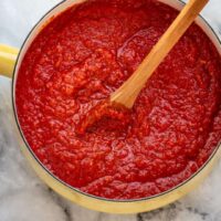 Saucepan with simmering pizza sauce.