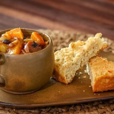 baked beans with butternut squash and smoked sausage on a plate with cornbread
