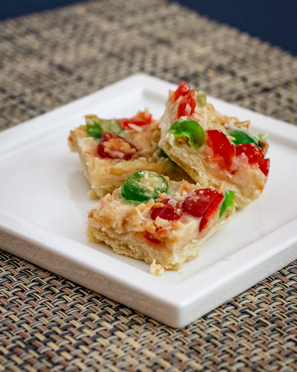 Cheesy vegetable pizza squares on a white plate.