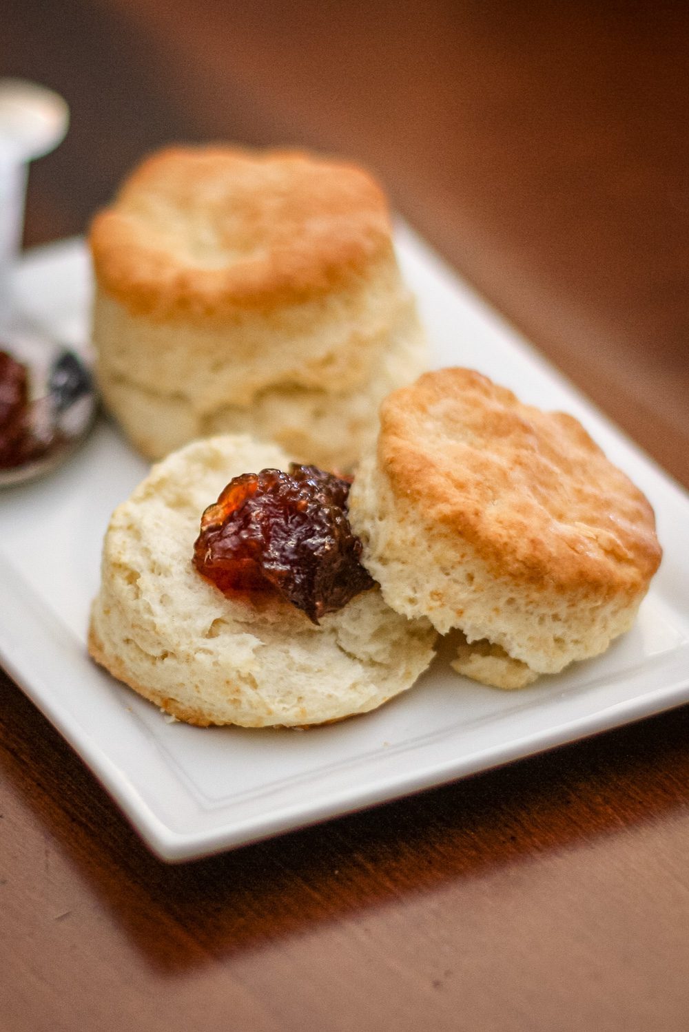 flaky buttermilk biscuits on a plate with jam