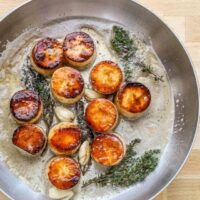 Seared scallops with garlic and herbs in a buttery sauce.