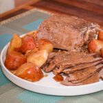 slow cooker pot roast, potatoes, and gravy on a platter