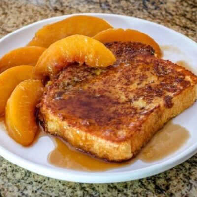 french toast on a plate with caramelized peaches