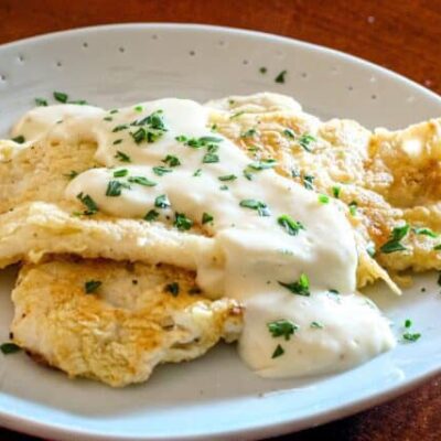 pan fried sole on a plate with parmesan sauce