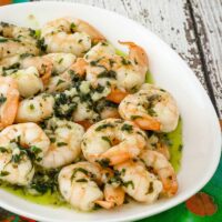 Garlic butter shrimp on a plate with parsley.