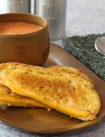 a basic grilled cheese sandwich on a sandwich plate with tomato soup