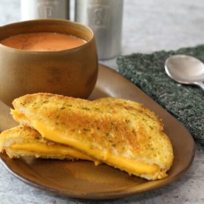 a basic grilled cheese sandwich on a sandwich plate with tomato soup
