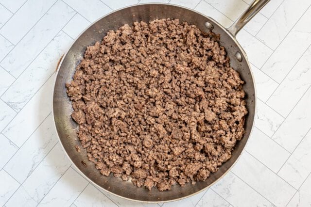 Browned ground beef in a skillet for casserole prep.