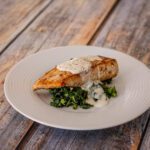 halibut on a plate with spinach and sauce