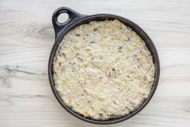 Creamy casserole mixture in a black skillet.
