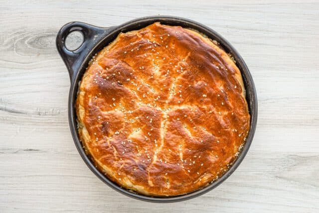 Golden baked pie in a cast iron skillet.