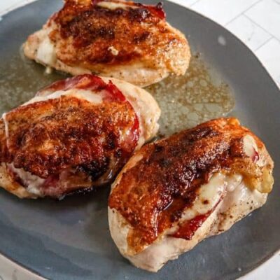 Serving tray with skin-on chicken breasts with capicola and provolone.