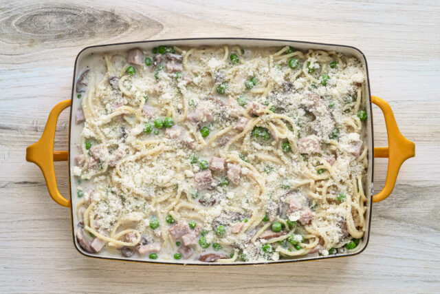 Ham tetrazzini topped with Parmesan cheese, ready to be baked.