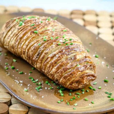 Golden baked potato rosette garnished with chopped chives and a sprinkle of salt.